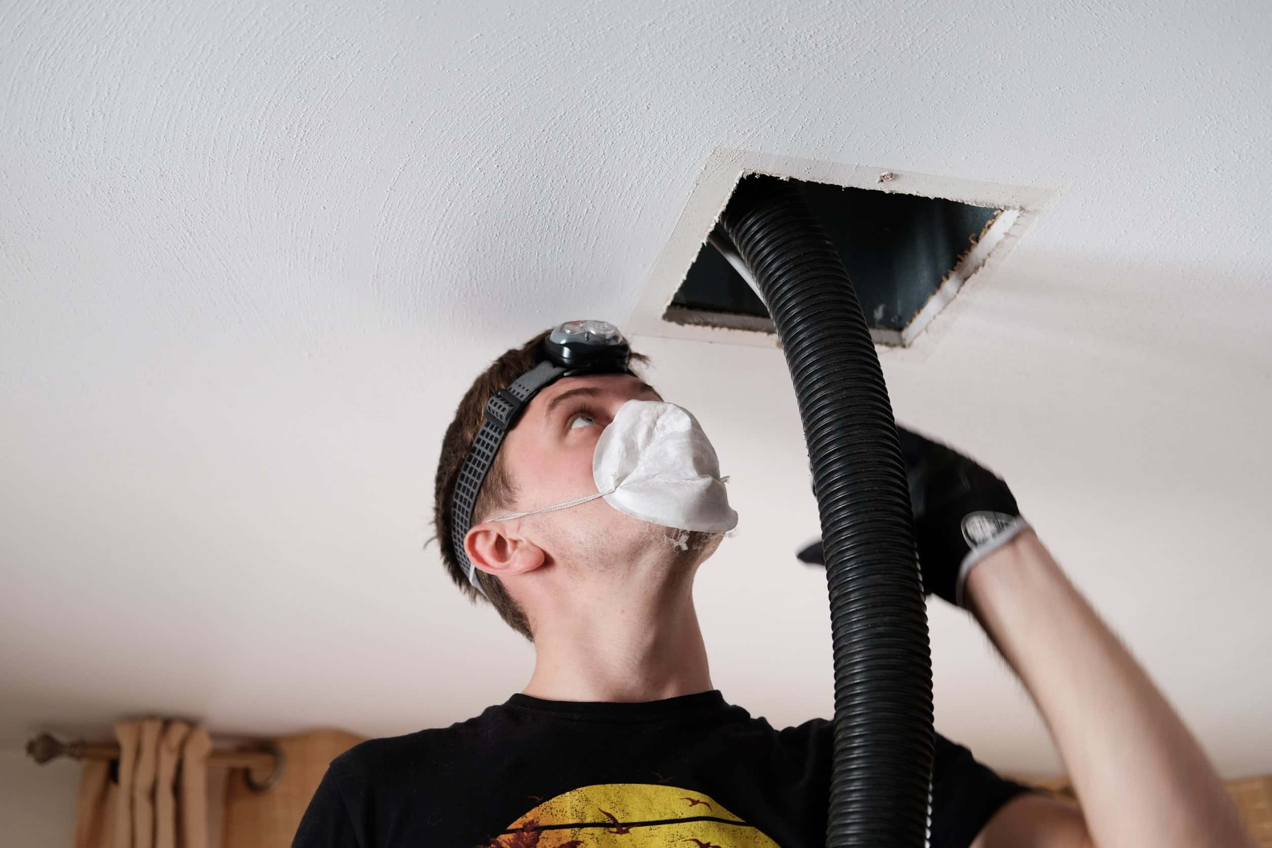 male technician cleaning air ducts in a manteca home