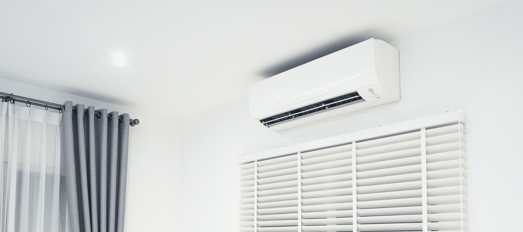 a white ductless ac unit installed above a window in a Manteca home